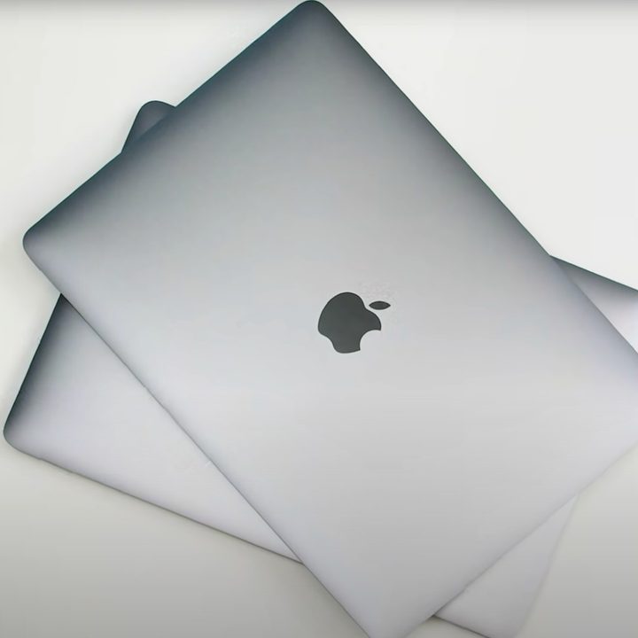 A stack of MacBooks is pictured from the top down.