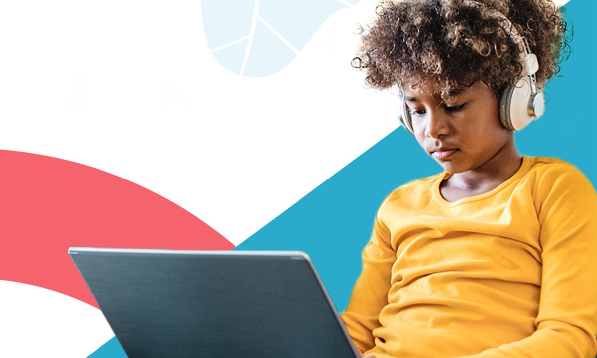 A child wearing a yellow shirt holding a chromebook in her lap