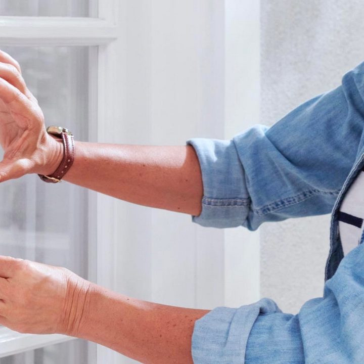 A woman releasing the battery on a Ring Video Doorbell.