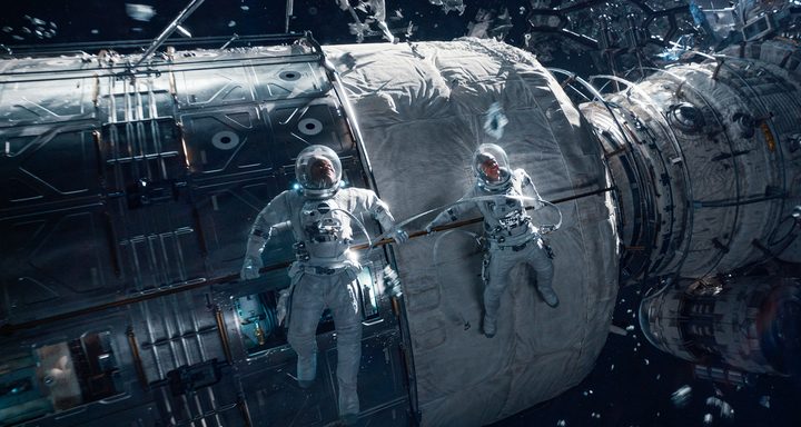Two astronauts float in space.