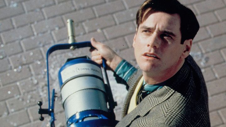 Jim Carrey as Truman Burbank looking up while holding a stage light in The Truman Show