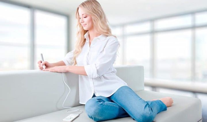 Woman sitting on couch using a Vitastiq 2