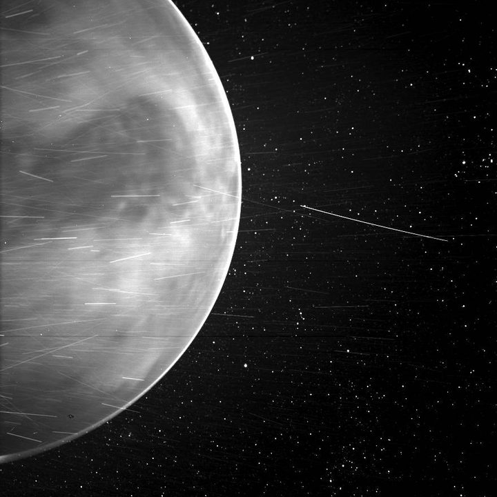When flying past Venus in July 2020, Parker Solar Probe’s WISPR instrument, short for Wide-field Imager for Parker Solar Probe, detected a bright rim around the edge of the planet that may be nightglow — light emitted by oxygen atoms high in the atmosphere that recombine into molecules in the nightside. The prominent dark feature in the center of the image is Aphrodite Terra, the largest highland region on the Venusian surface. Bright streaks in WISPR, such as the ones seen here, are typically caused by a combination of charged particles — called cosmic rays — sunlight reflected by grains of space dust, and particles of material expelled from the spacecraft’s structures after impact with those dust grains. The number of streaks varies along the orbit or when the spacecraft is traveling at different speeds, and scientists are still in discussion about the specific origins of the streaks here. The dark spot appearing on the lower portion of Venus is an artifact from the WISPR instrument.