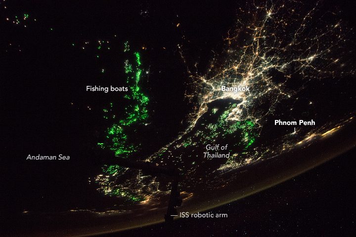 This oblique photograph, taken by an astronaut from the International Space Station, shows the city of Bangkok illuminated by city lights.