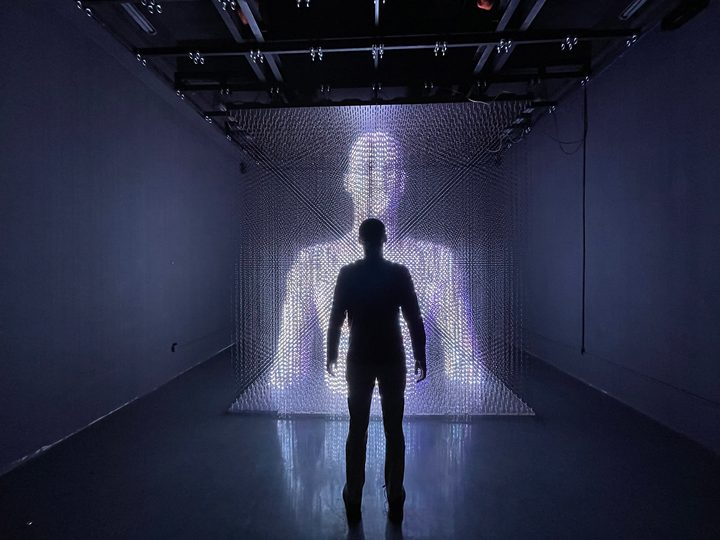 Man in front of LED Pulse volumetric display