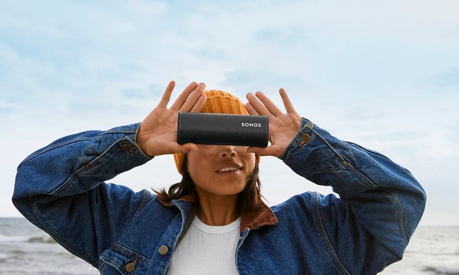 girl holding up sonos roam