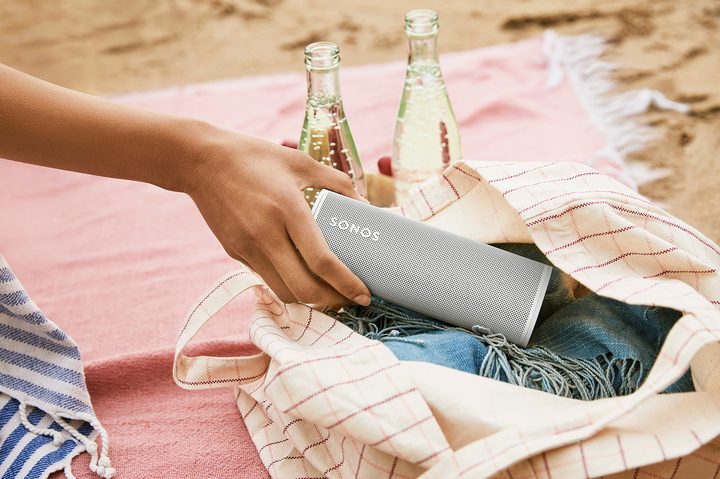 person putting white sonos roam in bag