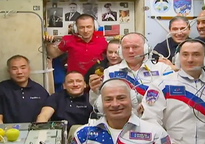The newly-expanded 10-member station crew gathers in the Zvezda service module for a welcoming ceremony with family members and mission officials on Earth.