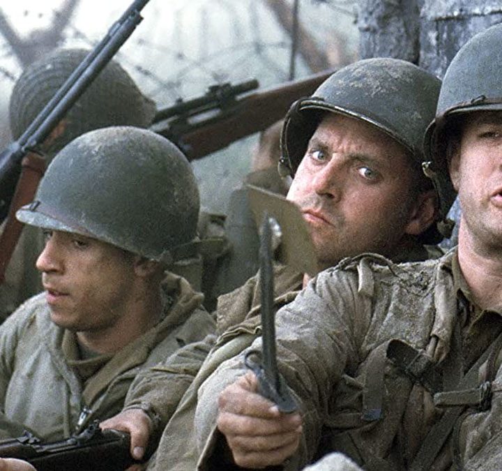 Soldiers group together on a battlefield in Saving Private Ryan.