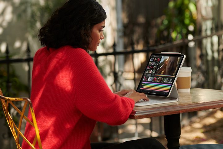 A person uses an M1 iPad Pro with a keyboard case while sat at a desk.