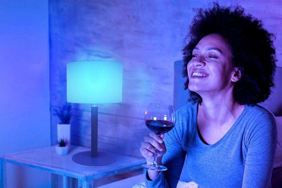 Woman having glass of wine with Govee Smart LED light bulb on.
