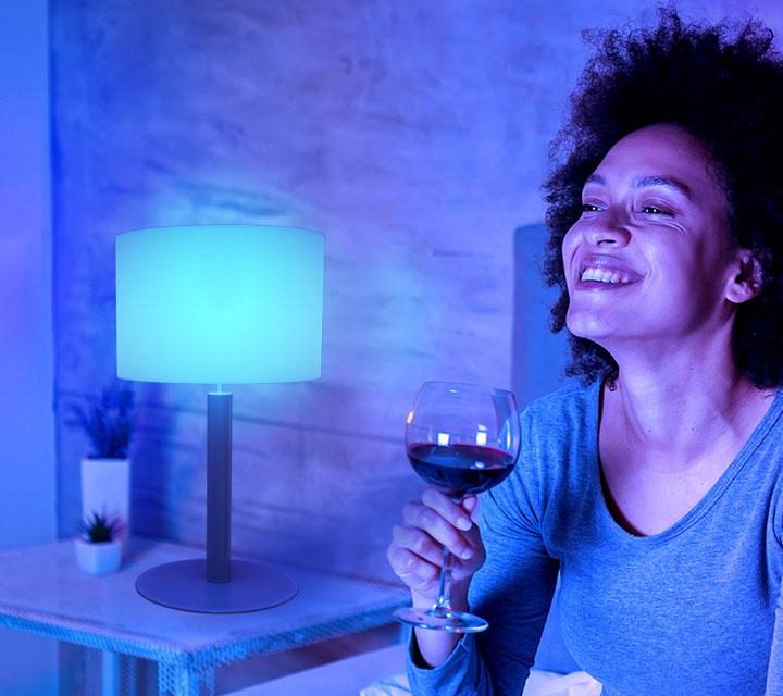 Woman having glass of wine with Govee Smart LED light bulb on.
