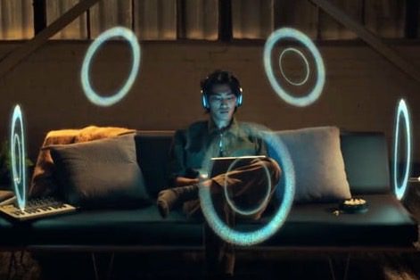 Person listening to spatial audio using Apple AirPods Max headphones.
