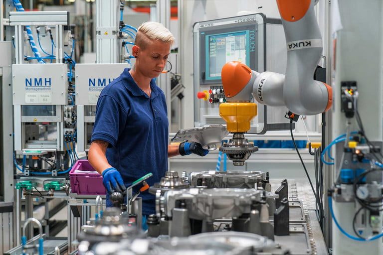 BMW factory worker using robotic arm