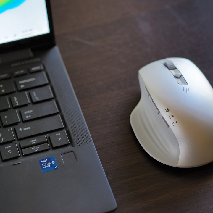 The HP 930 Creator Wireless Mouse next to a laptop.