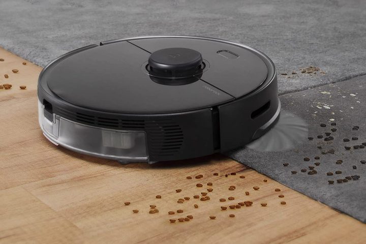 A Roborock S5 sucking up dirt on the floor.