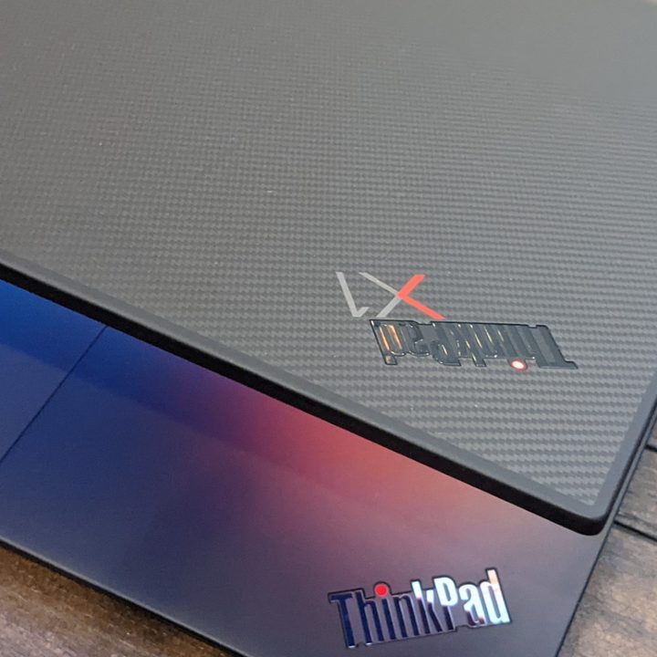 Top-down view of the ThinkPad X1 Extreme on a wooden table with the lid open a small amount to reveal the trackpad.