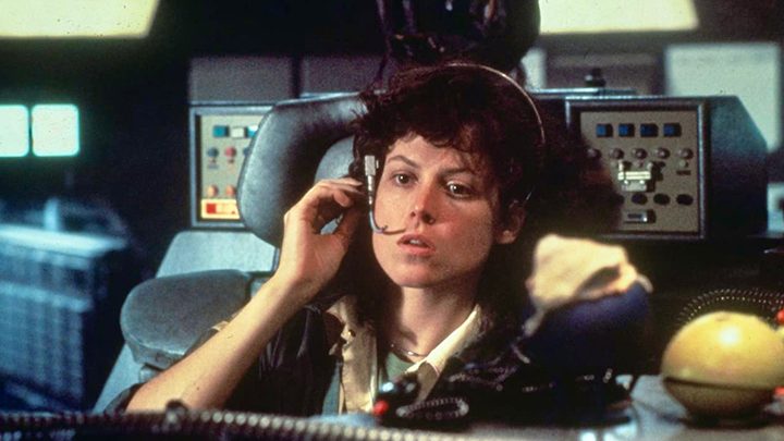 Sigourney Weaver on space ship with hand on headset in Alien.
