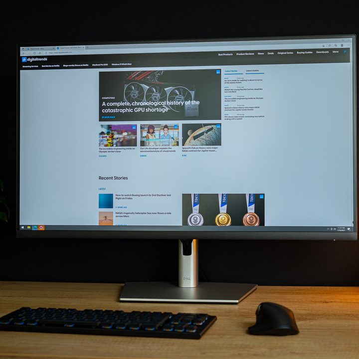 Dell 32 4K USB-C Hub monitor sitting on desk next to plant and light.