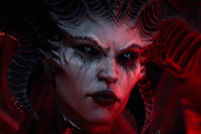 Diablo 4 promotional image of Lillith. It's a close-up shot and she's bathed in red light.