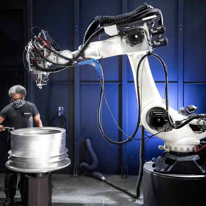 An engineer tests the thickness of a Relativity space rocket 3D print.