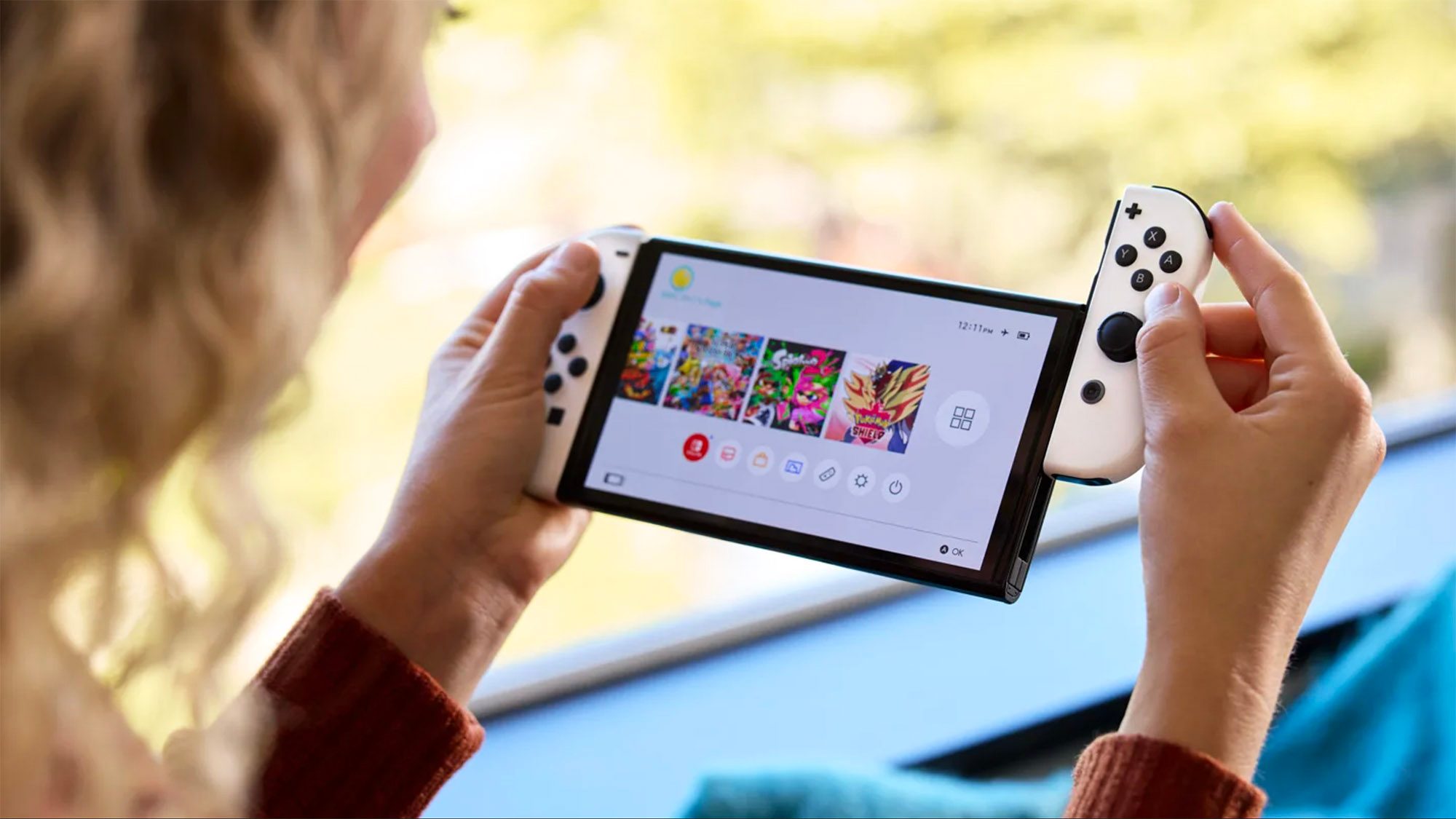 Person holding Nintendo Switch OLED.