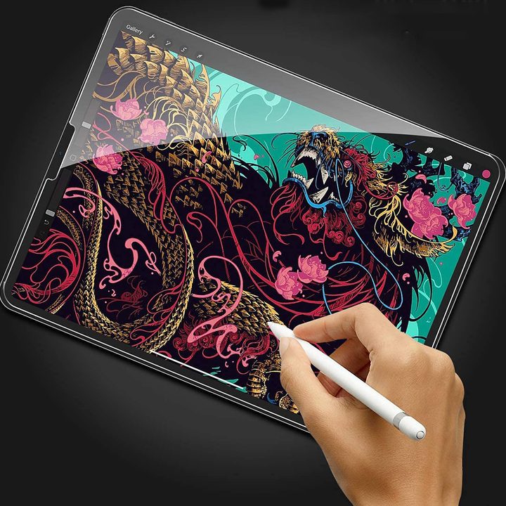 A person writing on an iPad that has an OMOTON screen protector.