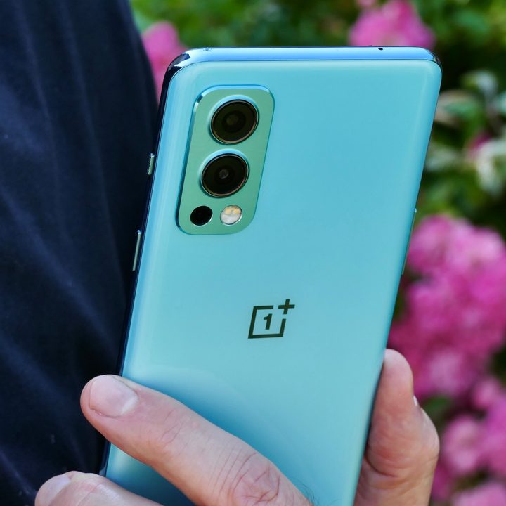 The OnePlus Nord 2 held in hand, seen from the back.