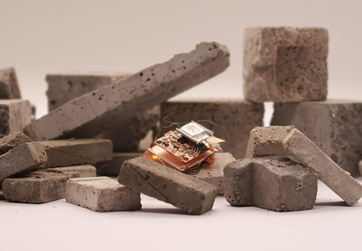 A tiny insect-sized robot is maneuvering over uneven blocks of stone. 