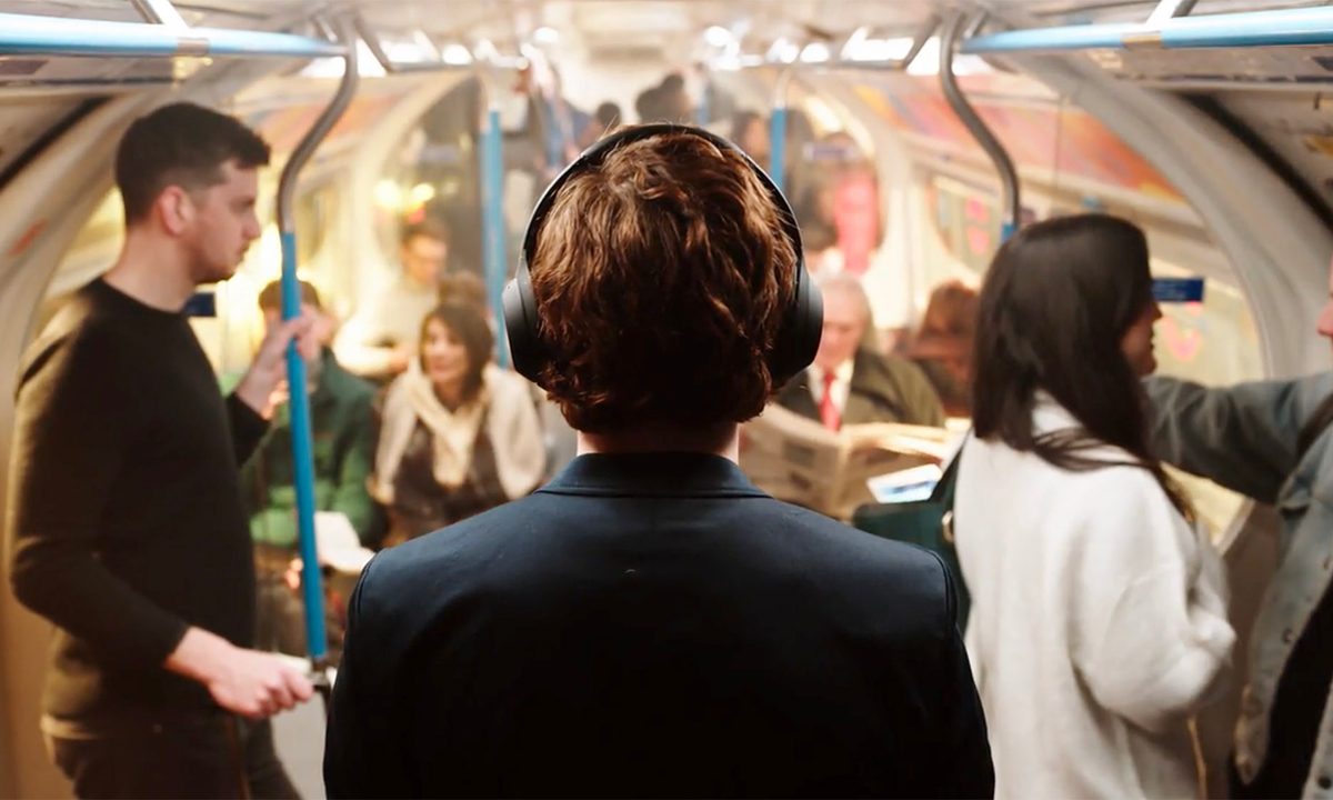 Man wearing Sony WH-1000XM4 ANC Headphones on public transportation.