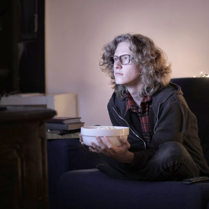 A photo of someone watching a movie on their couch.
