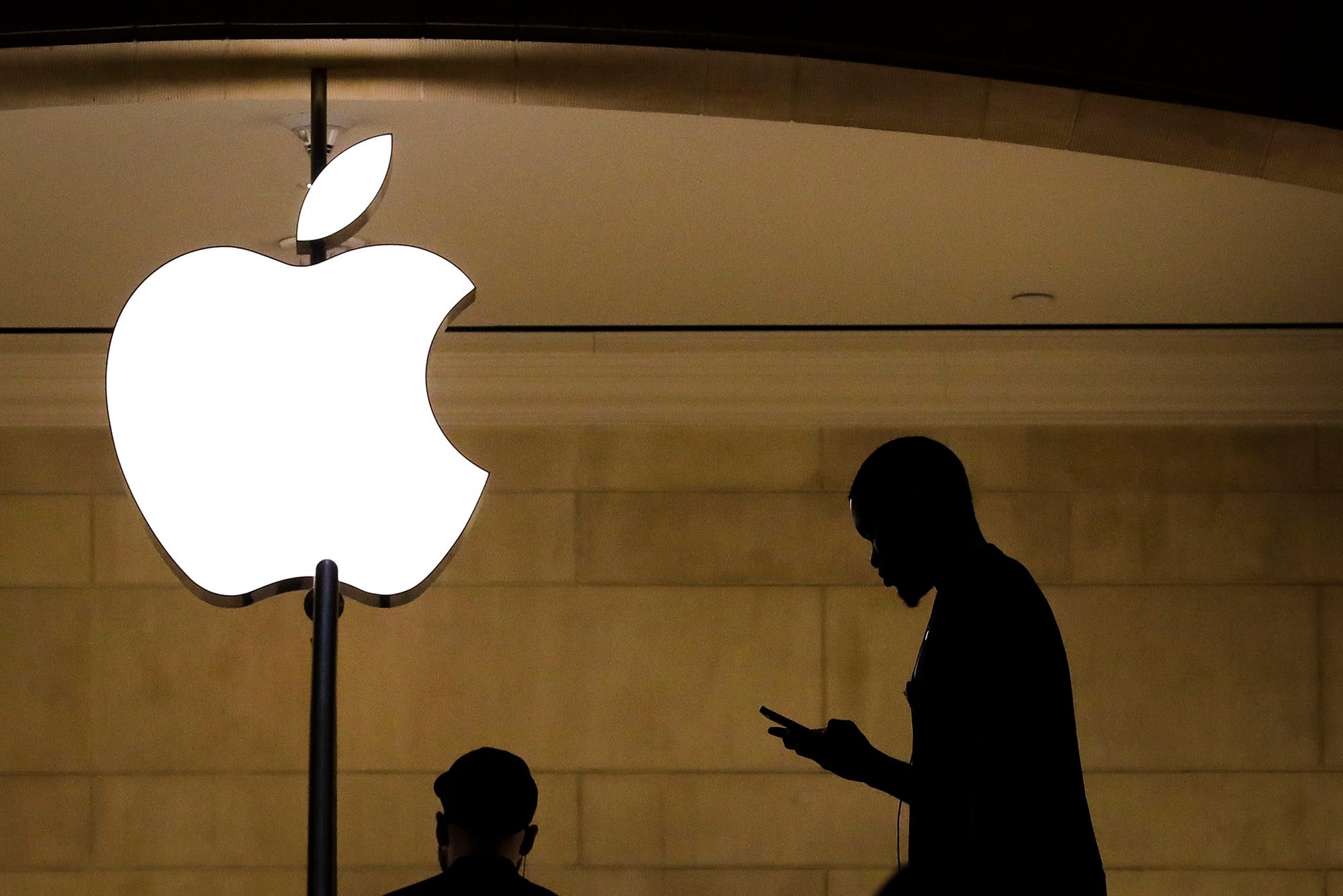 A man checks his phone in an Apple retail store in Grand Central Terminal.