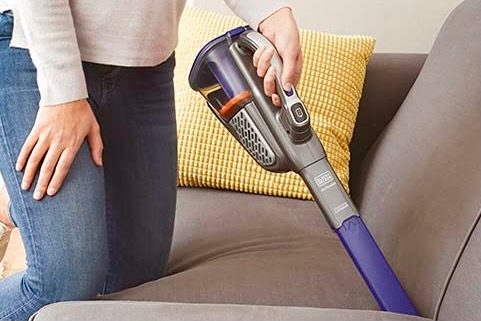 The Black + Decker Dustbuster being used on a couch.