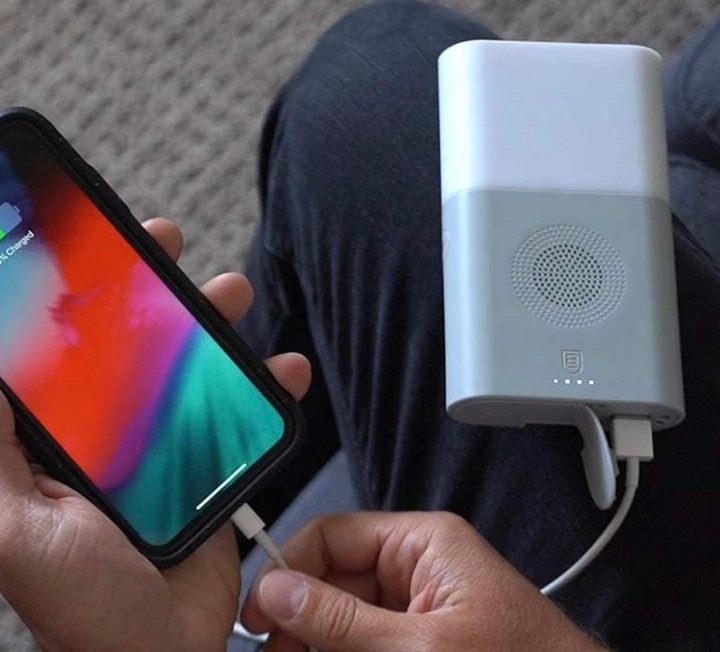 A person using the BodyGuardz Emergency Hub to charge their phone.