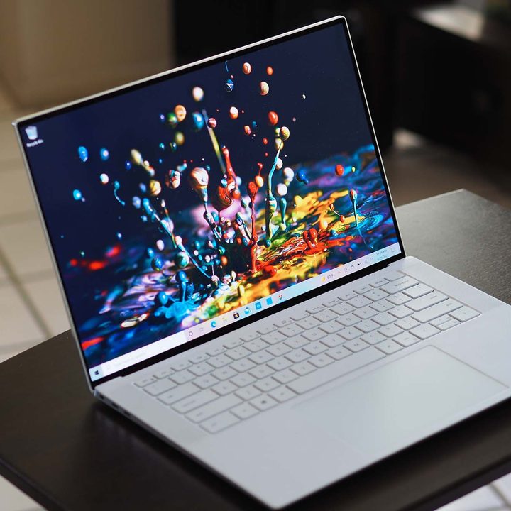 Dell XPS 15 OLED laptop sitting on a small table.