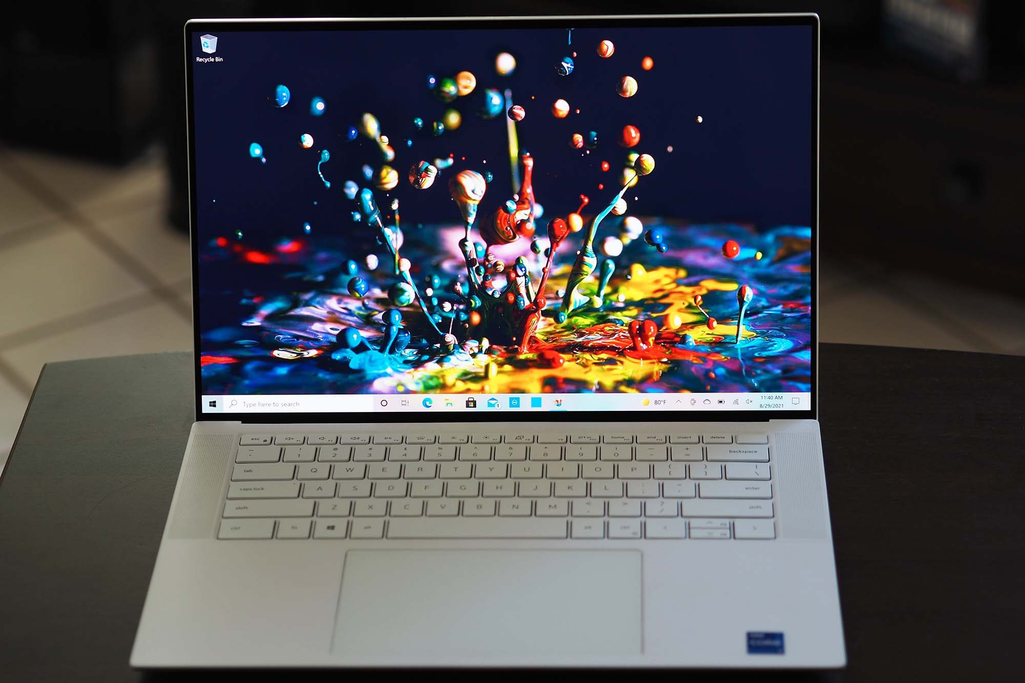Dell XPS 15 OLED laptop sitting on a small table.