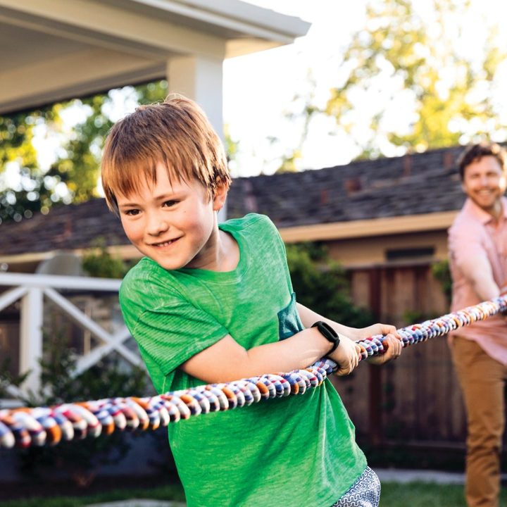 A child playing tug of war while wearing Fitbit Ace 3.