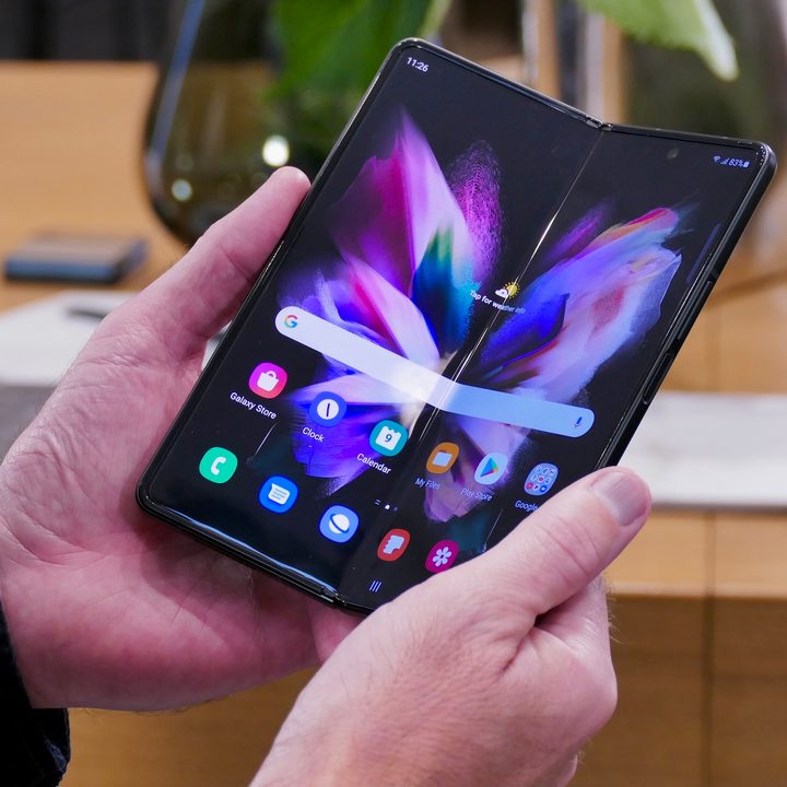 Galaxy Z Fold 3 almost open in hand.
