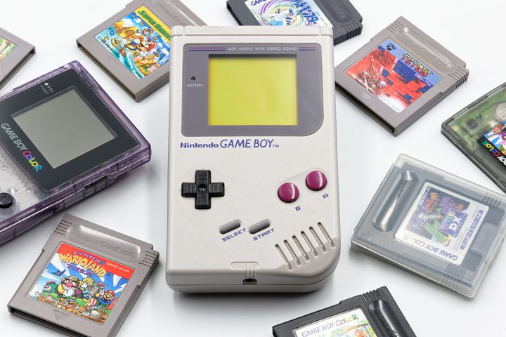 Nintendo game boy and game boy color with various hit game cartridges isolated on white background.