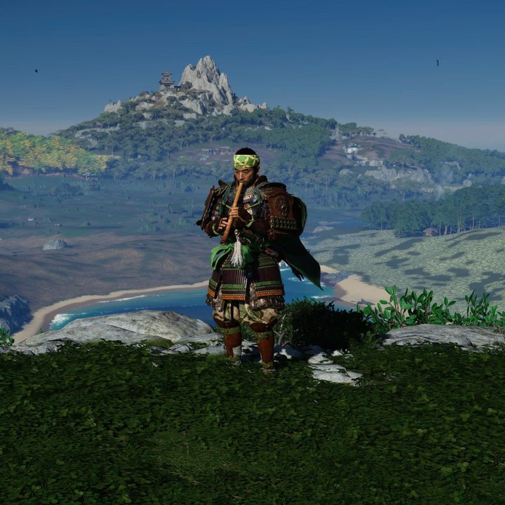 Jin plays his flute as Iki Island looms in the background.