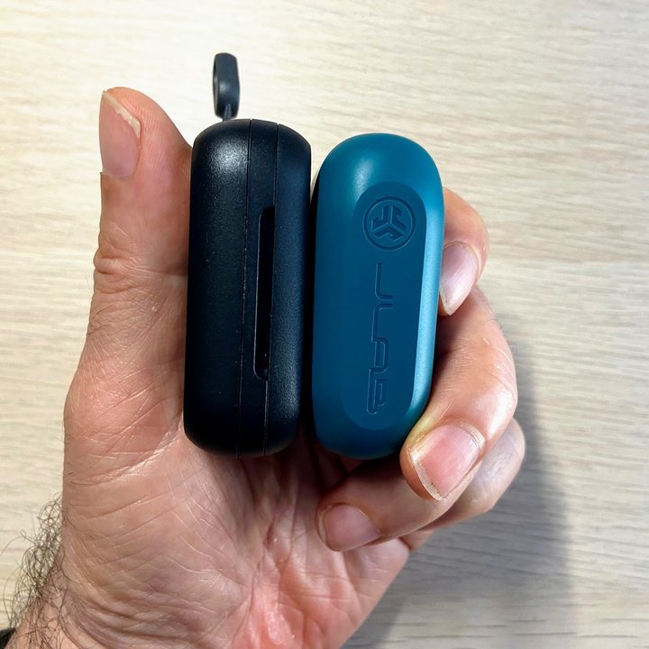 JLab Go Air Pop and Skullcandy Dime charging cases held in a hand.