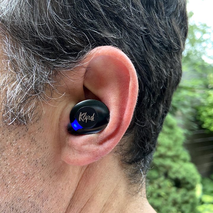 Close-up of man wearing Klipsch T5 II ANC true wireless earbuds.