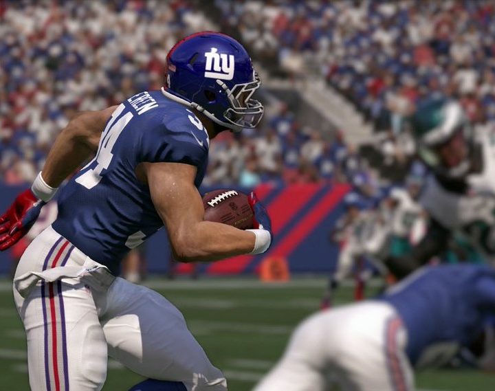 A Giants player carries the football in Madden.