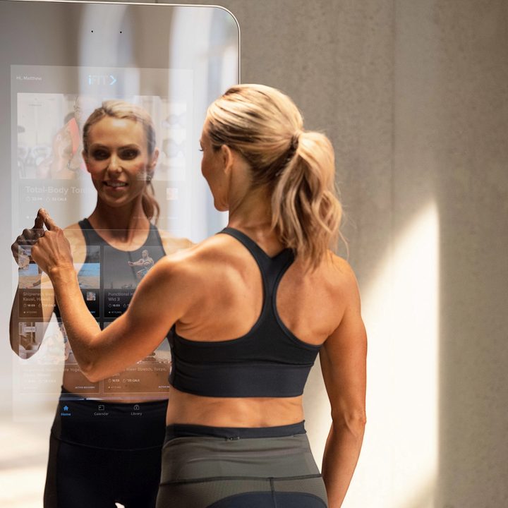 Woman touching screen with finger on the NordicTrack Vault.