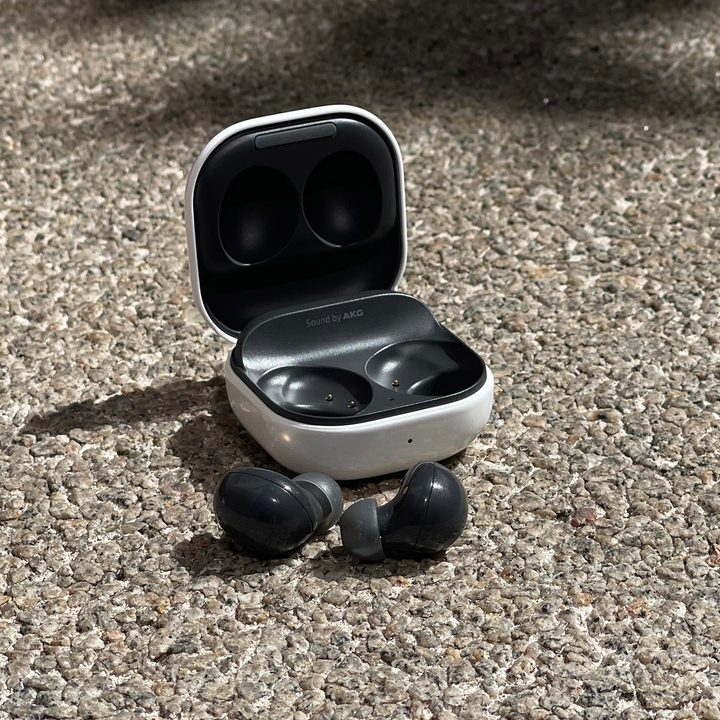 The Samsung Galaxy Buds 2 and their case sitting on the ground.