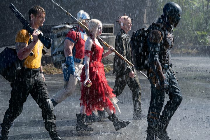 The cast of The Suicide Squad walking through the rain.
