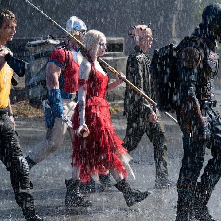 The cast of The Suicide Squad walking through the rain.