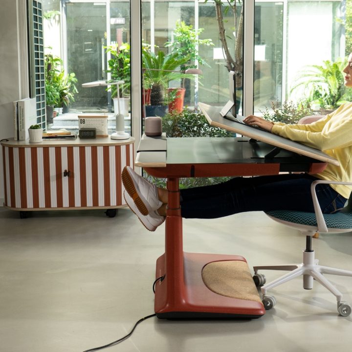 Female sitting in zero gravity position on Ufou Upon smart standing desk.