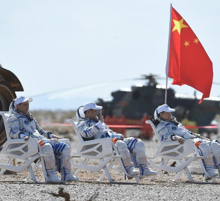 Astronauts Nie Haisheng (C), Liu Boming (R) and Tang Hongbo are out of the return capsule of the Shenzhou-12 spaceship at the Dongfeng landing site.