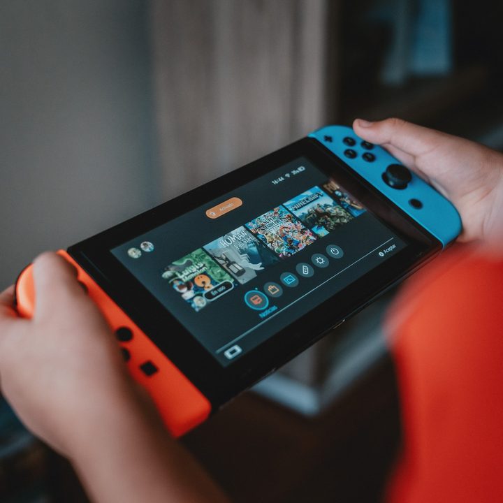 Person holding Nintendo Switch, looking at the home screen.